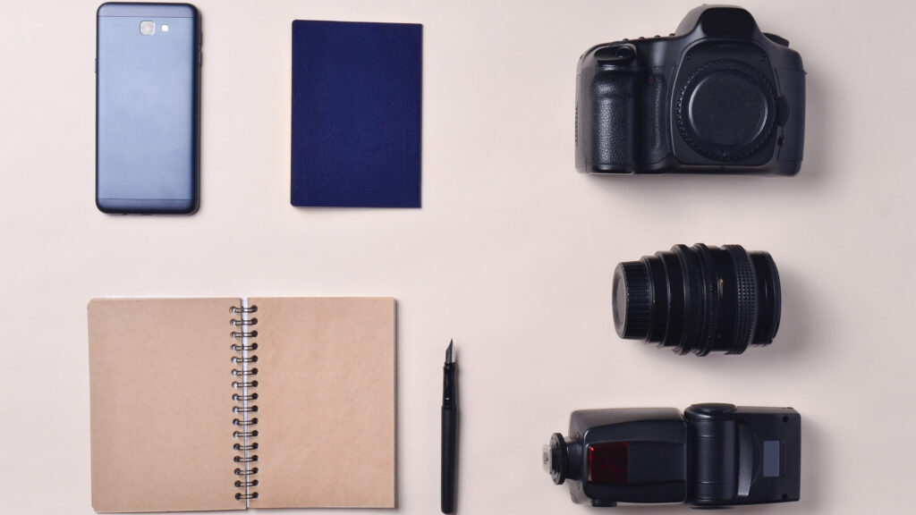 camera and phone and notebook on table